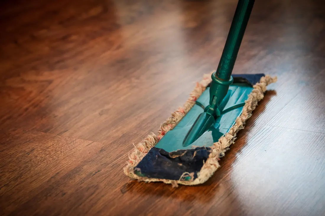 A flat mop cleaning a polished wood floor